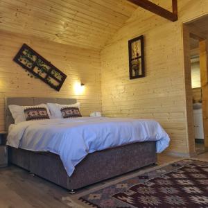 阿尔杰什河畔库尔泰亚Baltina Parc Transfagarasan的卧室配有一张木墙内的大床