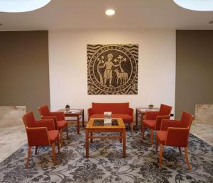 皮亚琴察贝斯特韦斯特公园酒店的一间设有红色椅子和墙上一幅画的等候室