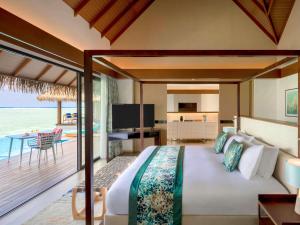 MaamutaaPullman Maldives All-Inclusive Resort的一间卧室配有一张床,享有海景