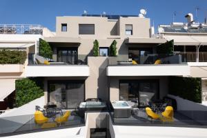 雅典LUX&EASY Athens Metro Suites的公寓大楼设有带黄色椅子的庭院