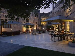 马泰拉马塞里亚圣卢西亚公寓式酒店的户外庭院在晚上配有桌子和遮阳伞