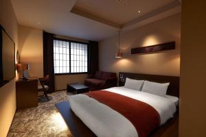 金泽Minn Kanazawa的酒店客房带一张大床和一把椅子