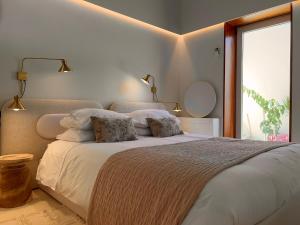 波尔图CASA DOS OLIVAIS的一间卧室配有一张带白色床单的床和一扇窗户。
