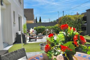 谢勒Suite avec piscine privée的阳台的庭院,种有红色的鲜花