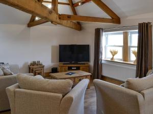 GilcruxGreengill Farm Holiday Cottage - Ukc2768的客厅配有电视、沙发和椅子