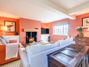 Great LimberLimber Wold House的客厅设有橙色墙壁、沙发和壁炉