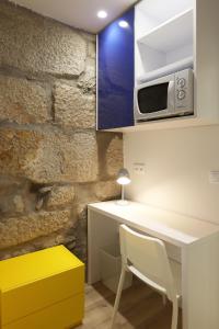 波尔图FLH Porto Downtown GuestHouse的厨房配有白色的桌子和微波炉