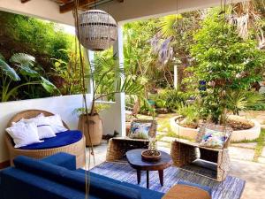 托弗海滩Hakha Beach House的天井设有蓝色的沙发、椅子和植物