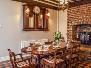 拉尔Heritage Lodge的一间设有桌子和墙上时钟的餐厅