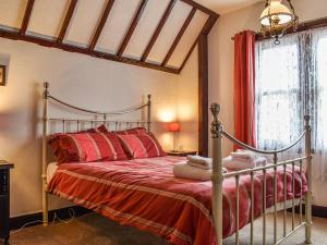 拉尔Heritage Lodge的一间卧室配有带红色床单的金属床和窗户。