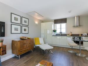 Shirland利特巴恩度假屋的厨房配有白色橱柜、书桌和桌子。