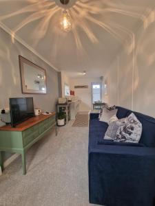 卡比斯贝Small Cottage close to Carbis Bay Beach & St Ives的客厅配有蓝色的沙发和电视