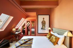 巴黎Hotel de Montesquieu的一间拥有橙色墙壁的卧室和一张位于客房内的床