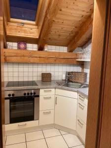 法尔先特Dachgeschosswohnung mit traumhaftem Zugspitzblick bei Garmisch的厨房配有炉灶和水槽