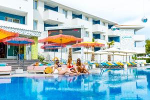 马盖鲁夫Sotavento Club Apartments - Adults Only的三个女孩坐在酒店游泳池里