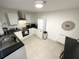 利物浦Wenlock Liverpool的厨房配有白色冰箱和白色瓷砖地板。