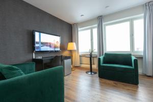 谢莱夫特奥维多利亚酒店的客厅配有绿色家具和平面电视