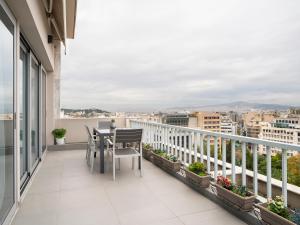 雅典雅典市中心阁楼公寓的大楼内的阳台配有桌椅