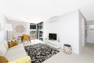 堪培拉CityStyle Apartments - BELCONNEN的带沙发和电视的白色客厅