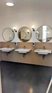 圣奇诺·迪·蒙塔尼亚Agricampeggio La Part ONLY CAMPER的浴室设有3个水槽和2面镜子