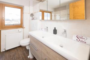 阿尔普巴赫谷地赖特西尔维亚住宿加早餐旅馆的白色的浴室设有水槽和卫生间。