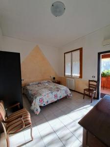 帕尔马Affittacamere Da Franco的卧室配有1张床、1张桌子和1把椅子