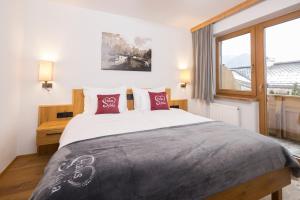 阿尔普巴赫谷地赖特西尔维亚住宿加早餐旅馆的一间卧室配有一张带红色枕头的大床