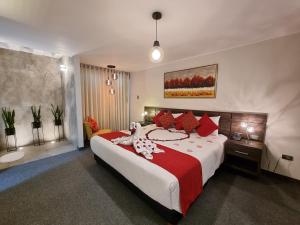阿雷基帕Hotel La Gruta的一间卧室配有一张带红色枕头的大床