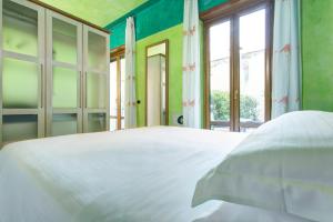 维罗纳Hotel Firenze的卧室设有白色的床和大窗户