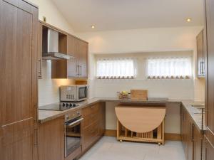 肯莫尔Deuchars Cottage的厨房配有木制橱柜和台面