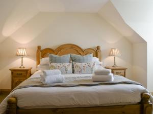 肯莫尔Deuchars Cottage的一间卧室配有带毛巾的床