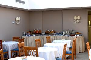 罗马BeYou Hotel Ponte Milvio的用餐室配有桌椅和白色桌布