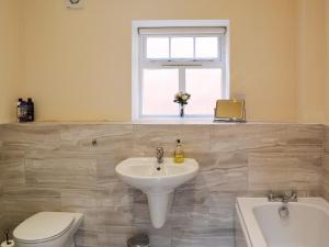 binbrookGranary Lodge的一间带水槽和卫生间的浴室以及窗户。