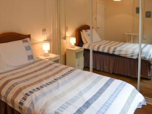 伯克顿Rosemarys Sea View的小房间设有两张床和两盏灯