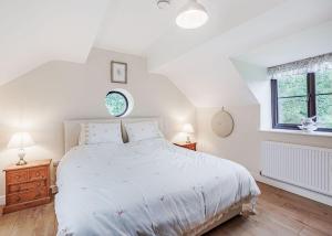 Pen-y-bont-fawrSgubor Fach的白色卧室设有一张大床和两个窗户