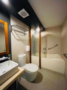 那牙Villa Rosita Hotel的浴室配有卫生间、盥洗盆和浴缸。
