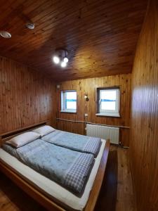 SepeneKurzemes pērle的木制客房内的一间卧室配有一张大床