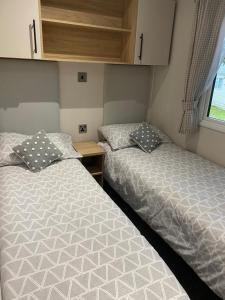 海斯廷斯Coghurst Hall Holiday Home Sleeps 6, 2 bedrooms的小型客房设有两张单人床和窗户。