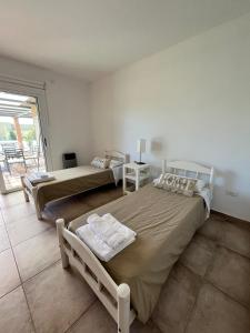 Vista FloresPergolas Guest House - Pileta, Vinos y Montaña的一间带两张床的卧室和一个阳台