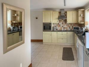 North SomercotesNursery Cottage的厨房配有白色橱柜和瓷砖地板。
