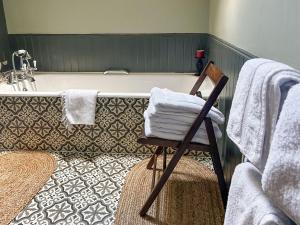 阿伯福伊尔克雷格达拉奇度假屋 的带浴缸的浴室以及带毛巾的椅子。