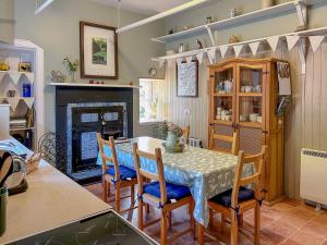 阿伯福伊尔克雷格达拉奇度假屋 的厨房配有桌椅和壁炉。