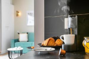 巴黎Sweet Inn - Pont Neuf的一张桌子,上面放着一盘羊角面包和一杯咖啡