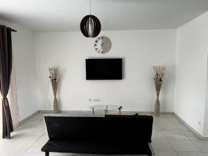MatouryMaison T3 neuve fonctionnelle的客厅配有黑色沙发和电视