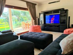 哈特比斯普特Spacious Golf & Wildlife Estate in Hartbeespoort 10 sleeper的带沙发的客厅和带电视的客厅