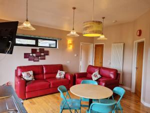 切达Tor Farm Lodge的客厅配有红色的沙发和桌子
