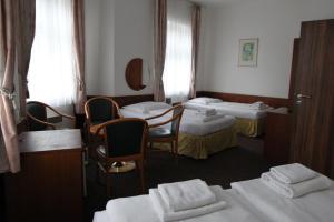 小斯卡拉斯卡拉酒店的带三张床和桌椅的房间