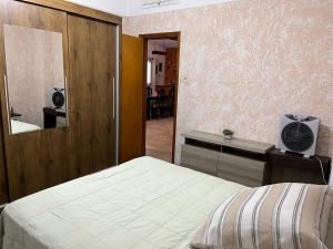 皮里亚波利斯Barrio Country的一间卧室配有一张床、梳妆台和镜子