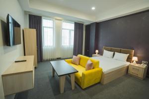 巴库Ogguesto Hotel的酒店客房设有床和黄色沙发