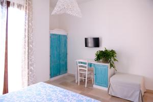 切萨雷奥港Villa Sofia Bed and Breakfast的一间卧室配有蓝色橱柜和一张桌子